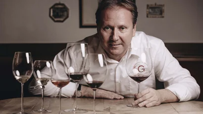 Mann sitzt am Tisch mit fünf Weingläsern unterschiedlicher Weinsorten