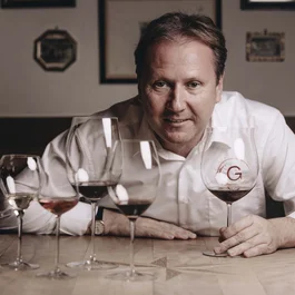 Mann sitzt am Tisch mit fünf Weingläsern unterschiedlicher Weinsorten