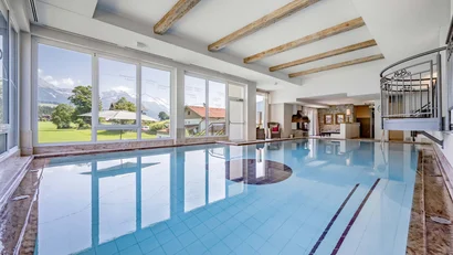 Innenpool mit großen Fenstern und Bergblick