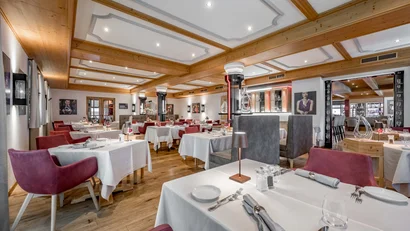 Elegantes Restaurant mit gedeckten Tischen und Holzdecke