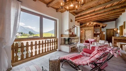 Gemütliches Wohnzimmer mit Holzbalkendecke und Bergblick