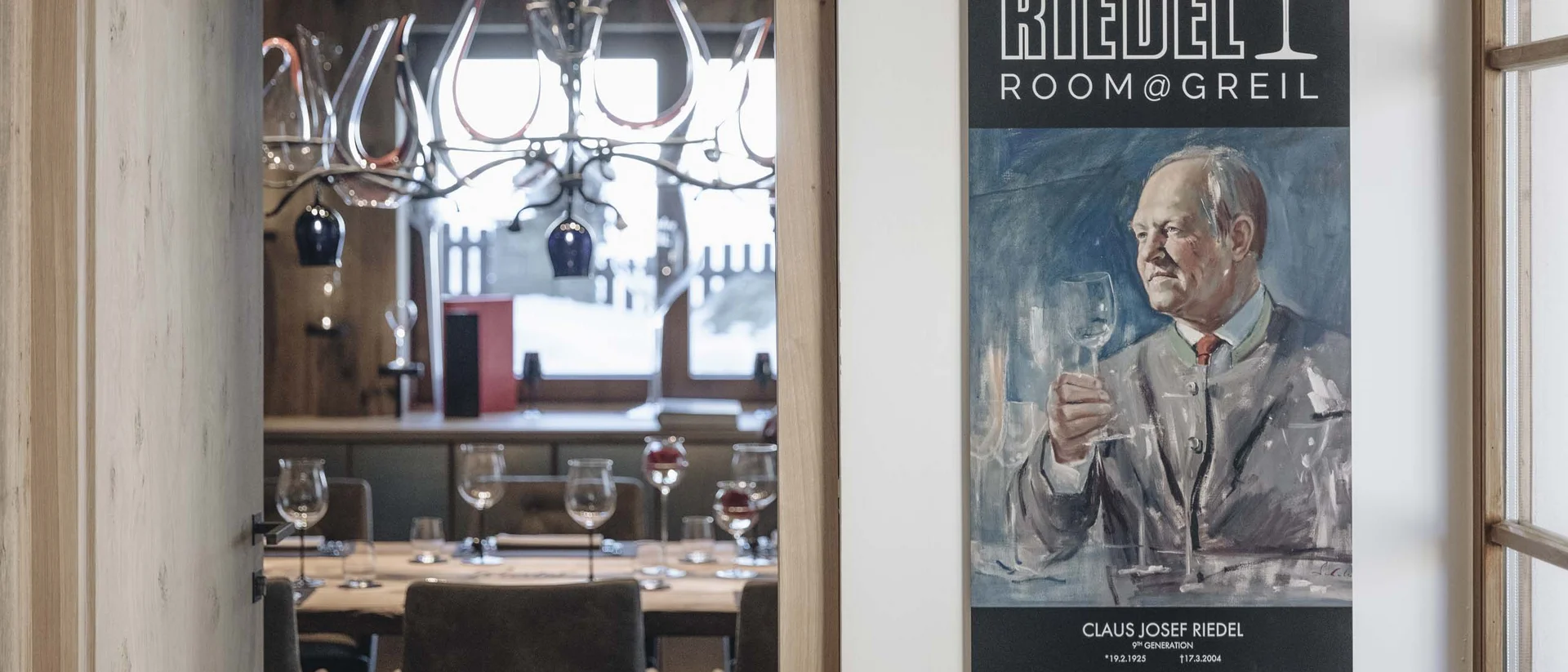 Blick in einen eleganten Speiseraum mit Riedel Room Greil Plakat