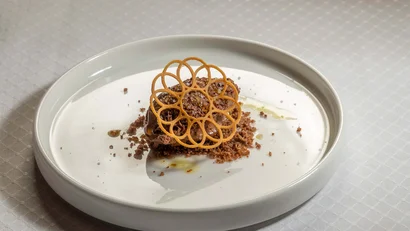 Dessert mit Schokoladenmousse und knuspriger Dekoration auf weißem Teller