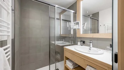 Modernes Badezimmer mit begehbarer Dusche und Holzmöbeln