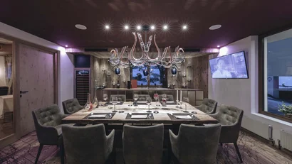 Moderner Essbereich mit Holztisch, Sesseln und eleganter Beleuchtung