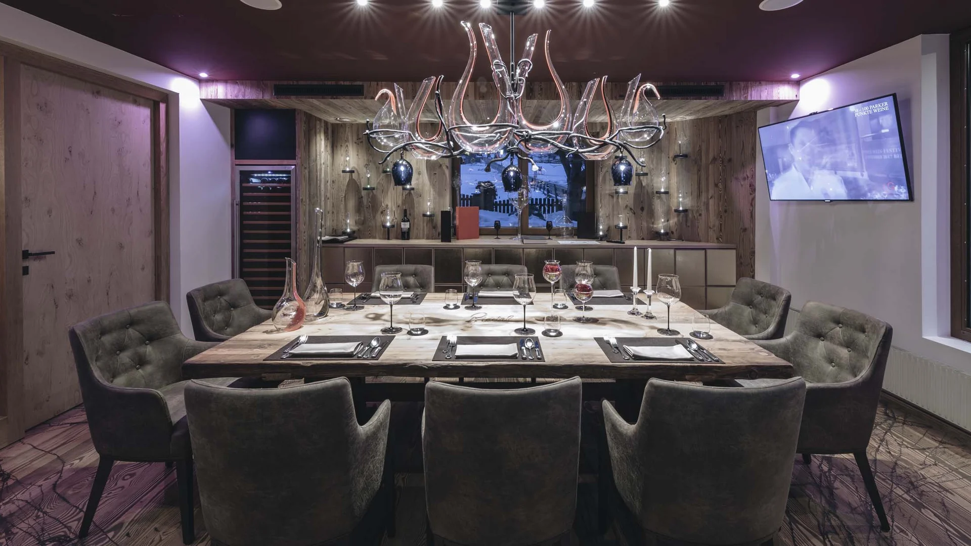 Moderner Essbereich mit Holztisch, Sesseln und eleganter Beleuchtung