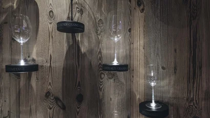 Verschiedene Weingläser beleuchtet vor einer Holzplatte